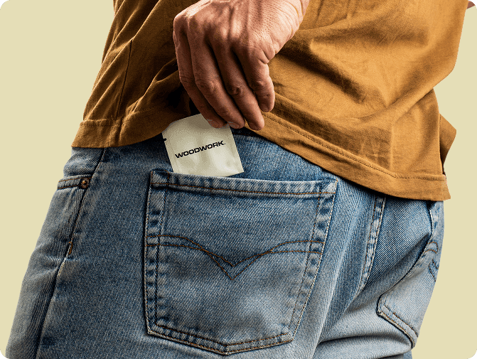 A man in jeans slips an individual Woodwork packet into his back pocket